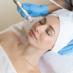 young-woman-lying-cosmetologist-s-table-rejuvenation-procedure-cosmetologist-take-care-about-neck-face-skin-youthfull-wellness-hardware-face-cleaning-procedure (1)